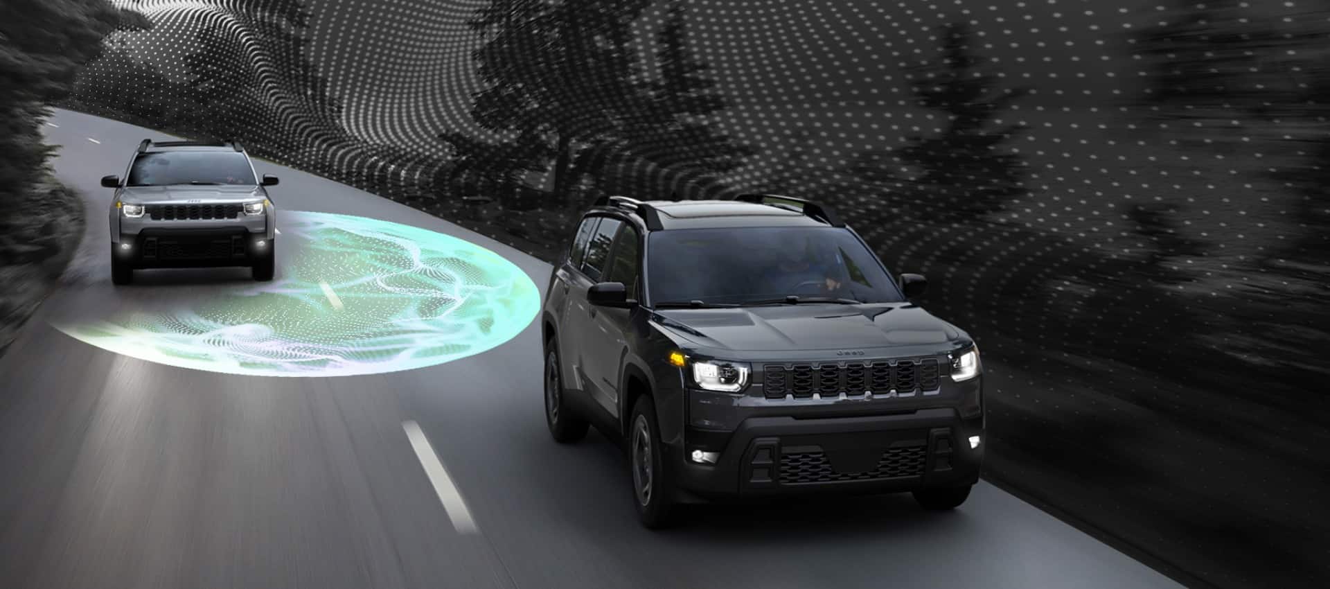 A black Jeep  Cherokee on a CGI road with a gray  Cherokee coming up next to it. A blue field of light emits from the gray  Cherokee to illustrate the range of the Blind Spot Monitoring system.