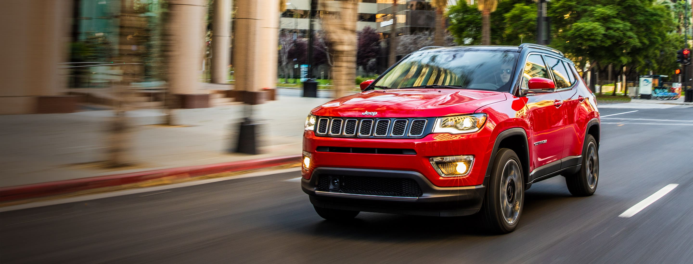 Un Jeep Compass andando por una calle de ciudad.