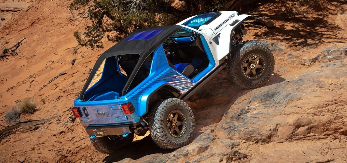 Display The Jeep Magneto 3.0 Concept climbing a steep rocky hill off-road.
