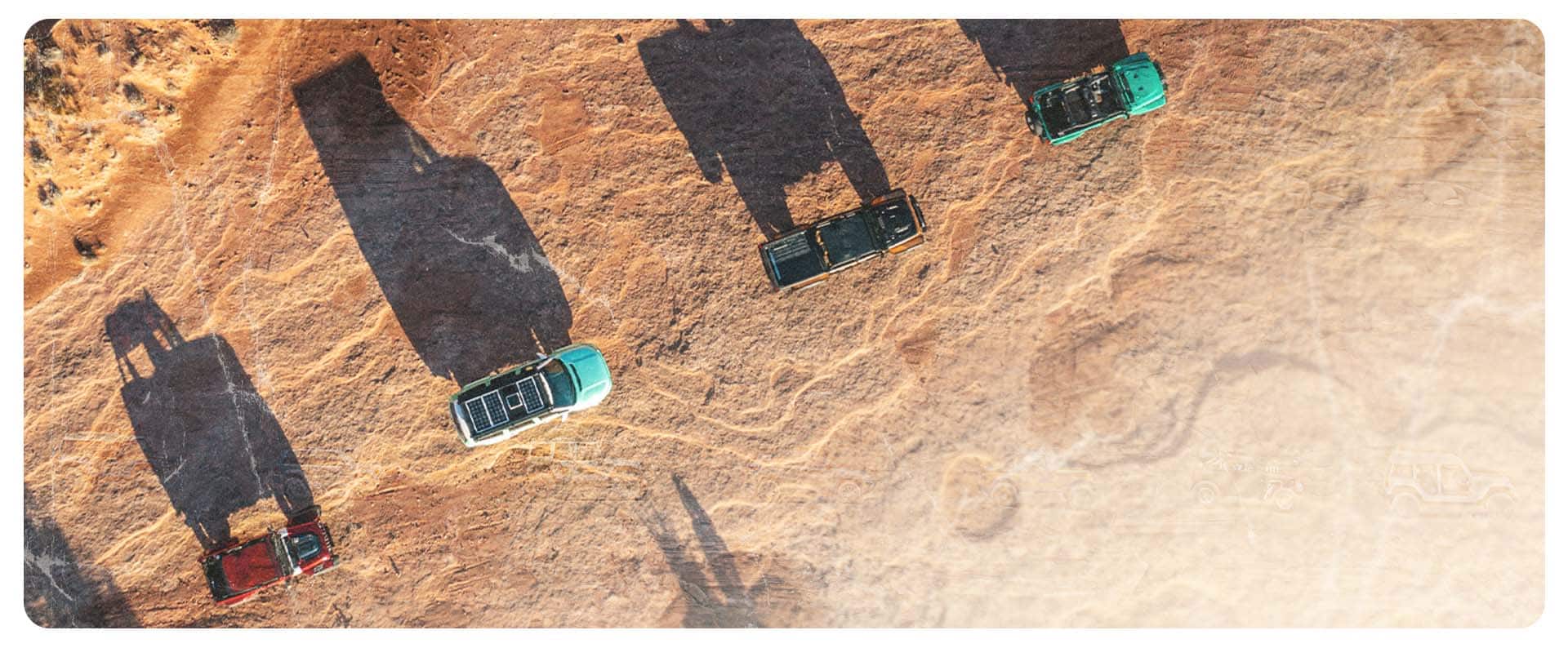 Vista aérea elevada de cuatro vehículos conceptuales de la marca Jeep avanzando uno tras otro por un sendero montañoso en Moab, Utah.