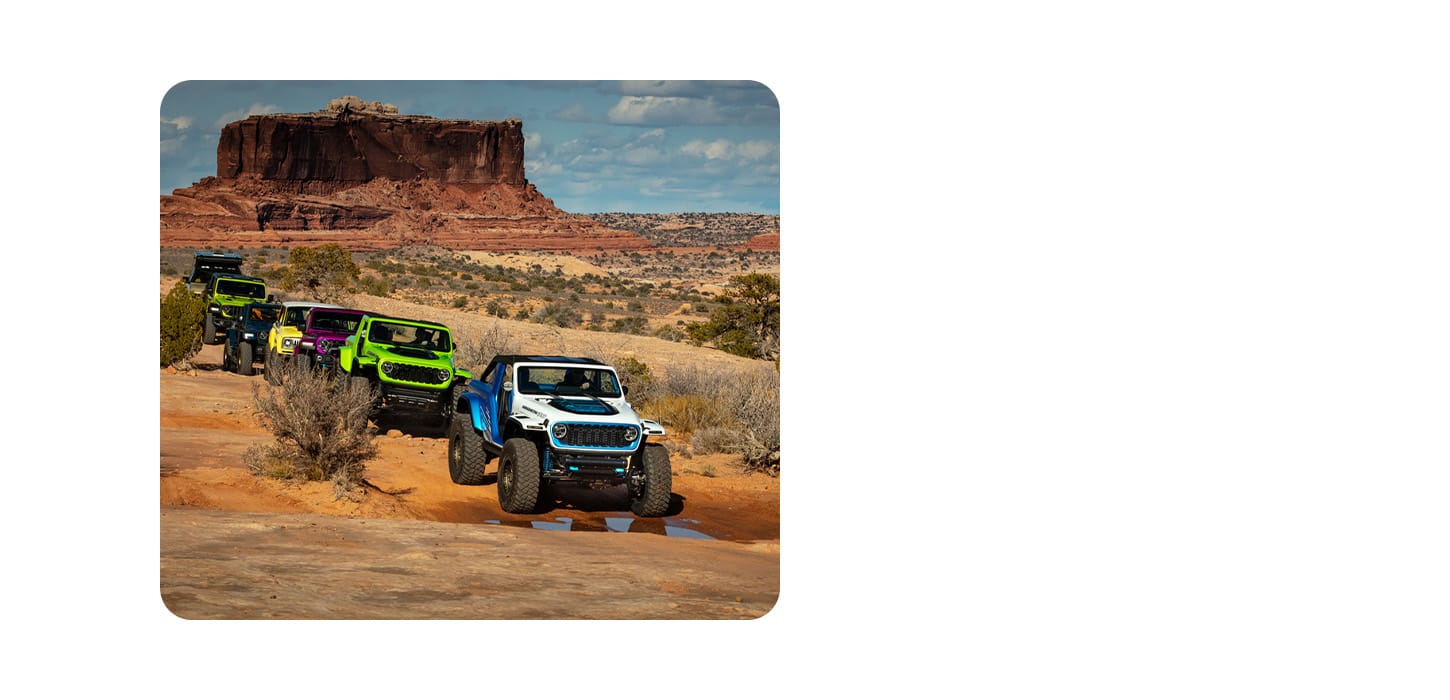 A caravan of seven Jeep Brand Concept vehicles being driven through the desert.