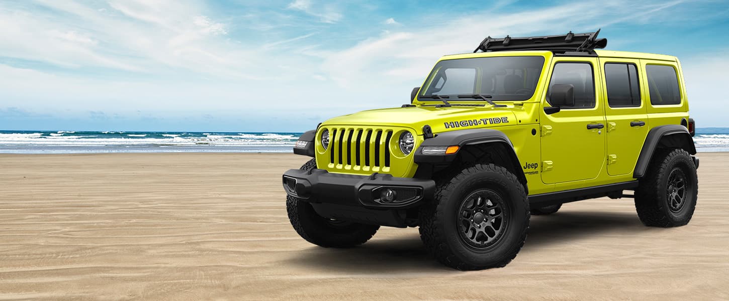 The 2022 Jeep Wrangler High Tide parked on a sandy beach.