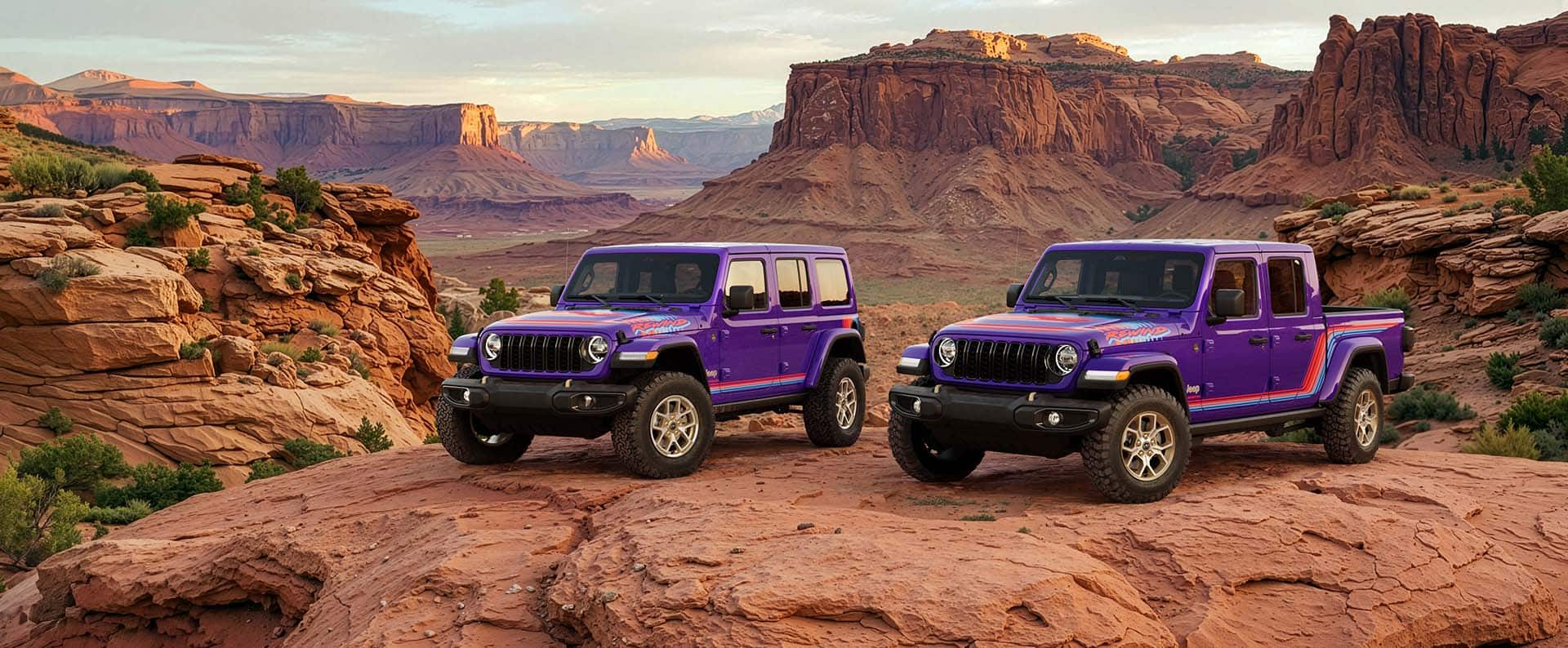 A purple 2026 Jeep Wrangler Rewind four-door and a purple 2026 Jeep Gladiator Rewind parked side-by-side on a clearing in the desert.