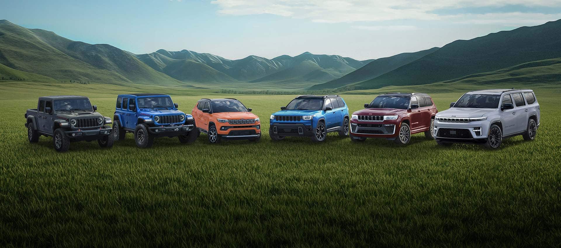 A lineup of six Jeep Brand vehicles parked on a grassy clearing with mountains in the background. From left to right: a gray 2026 Gladiator Mojave X, a blue 2026 Wrangler Rubicon X, an orange 2026 Compass Limited, a blue 2026 Cherokee Overland, a red 2026 Grand Cherokee Summit and a silver 2026 Grand Wagoneer Summit Reserve.