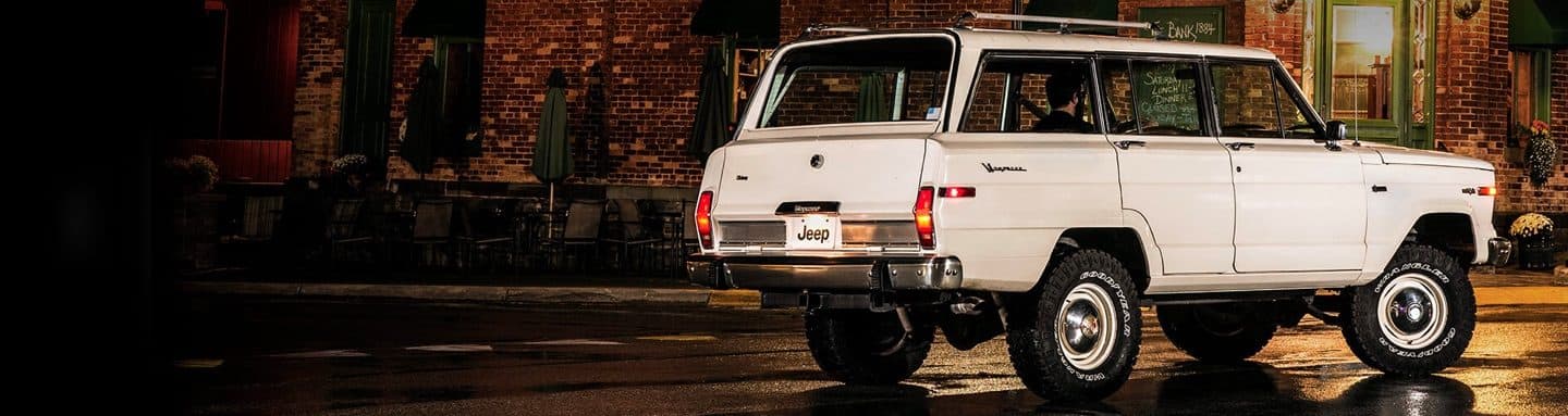 A three-quarter rear profile view of a Jeep Wagoneer parked on a city