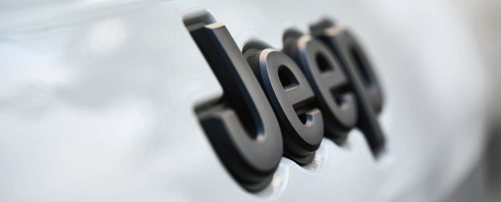 A close-up of the raised Jeep badge lettering on a Jeep Brand vehicle.