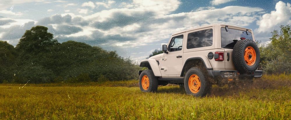 Wrangler JL-2A 2-door in Gobi in a grass field, rear three-quarter view