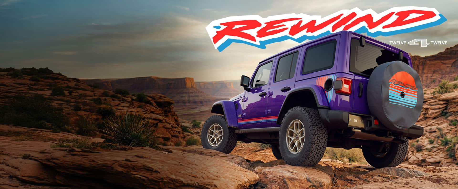 The rear of a purple 2026 Jeep Wrangler Rewind four-door with red and blue hood, fender and door decals, on a rocky hill off-road in the mountains. Rewind. 12 for 12.