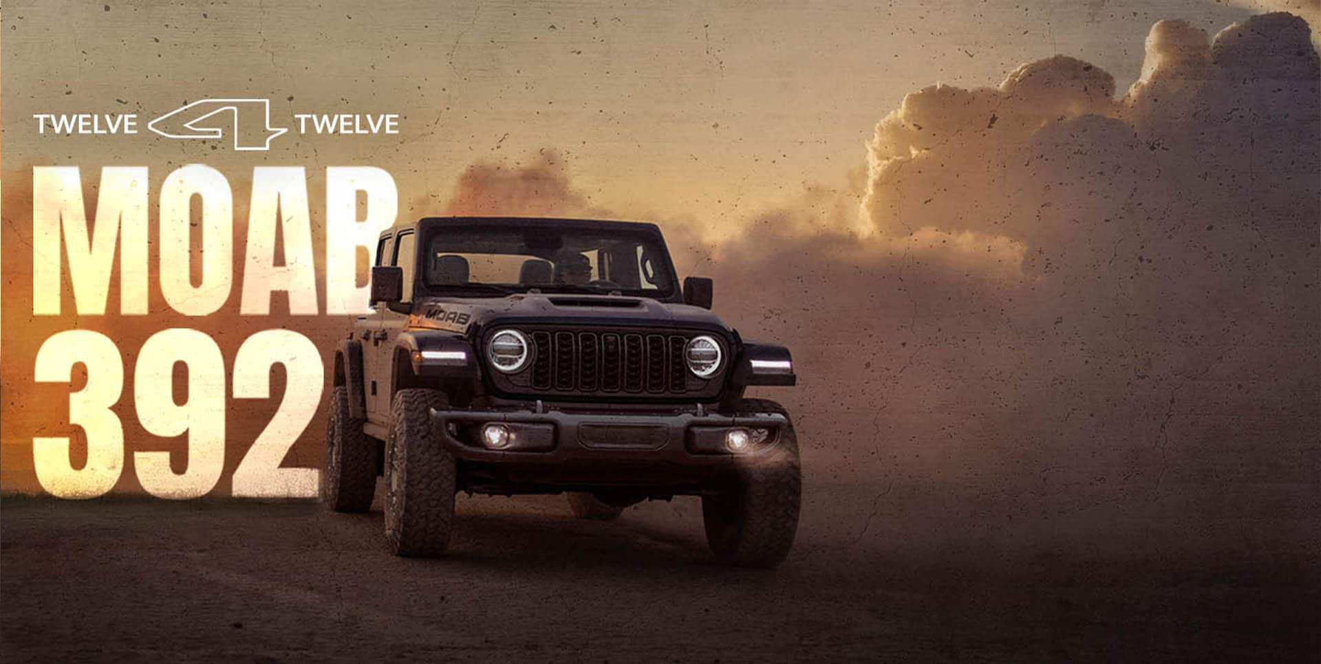 Un Jeep Wrangler Moab 392 2026 gris oscuro con nubes de humo elevándose al fondo. 12 para 12 Moab 392.