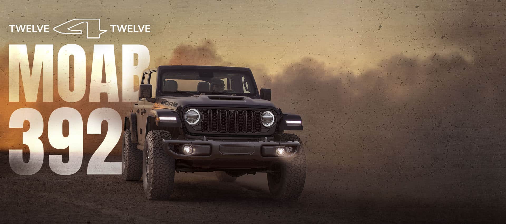 A dark gray 2026 Jeep Wrangler Moab 392 with clouds of smoke billowing in the background. 12 for 12 Moab 392.