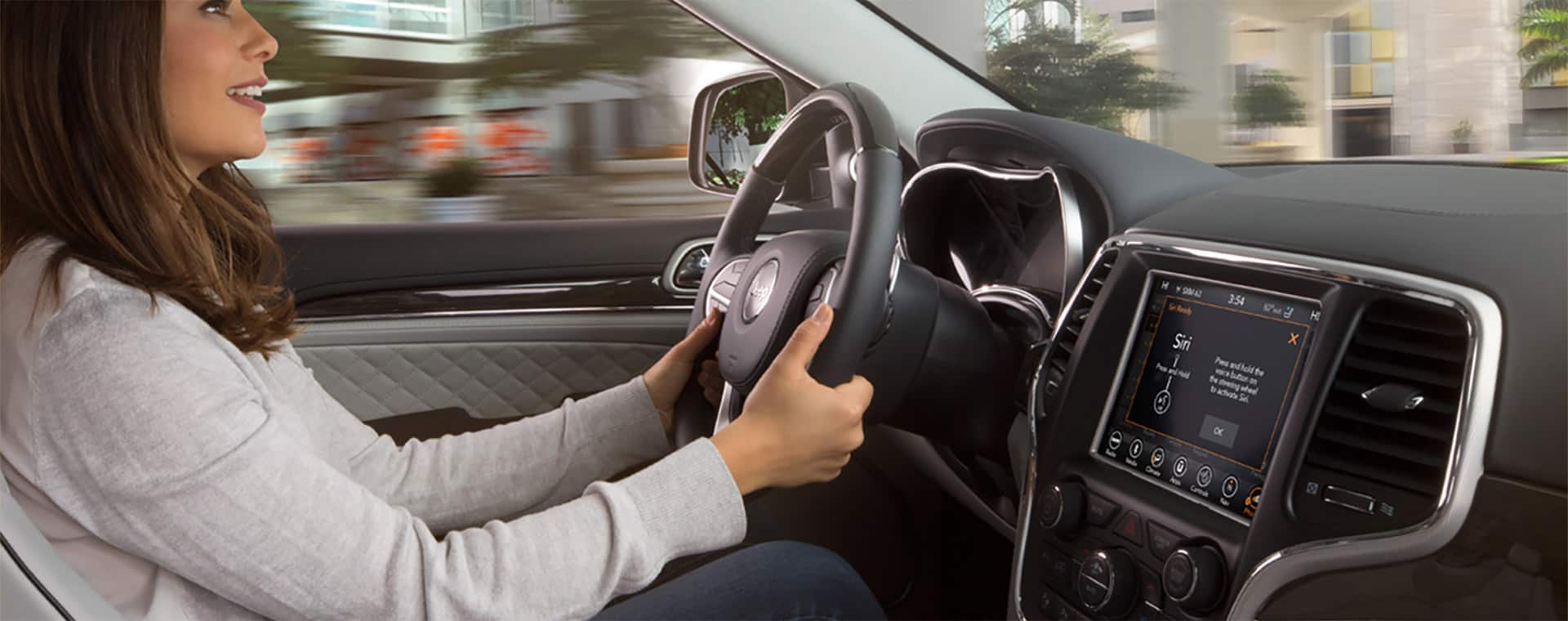 Woman driving with Siri on her vehicle's touchscreen.