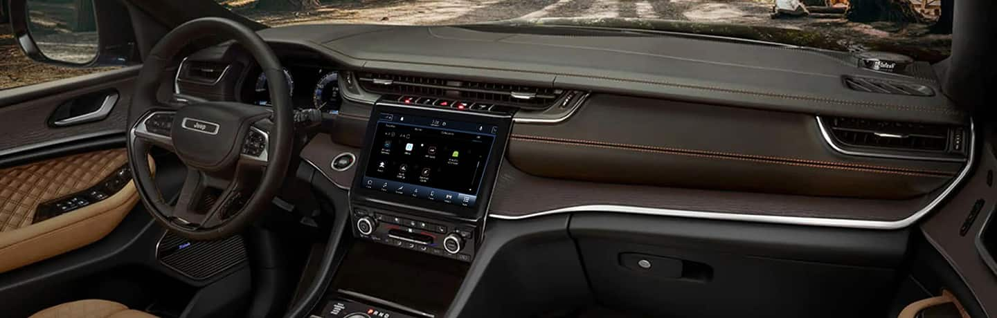 The steering wheel, Uconnect 5 touchscreen and dash in the 2022 Jeep Grand Cherokee Summit Reserve.