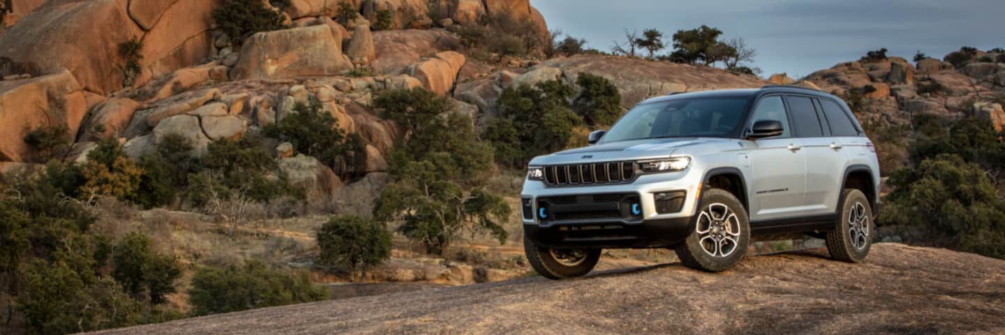 The 2023 Jeep Grand Cherokee 4xe parked off-road on a rocky plateau.