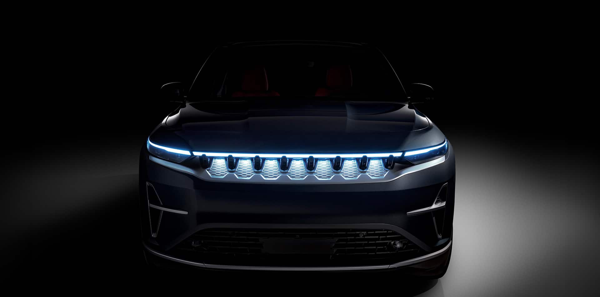 The front end of a black 2024 Jeep Wagoneer S Launch Edition with its seven-slot grille illuminated.