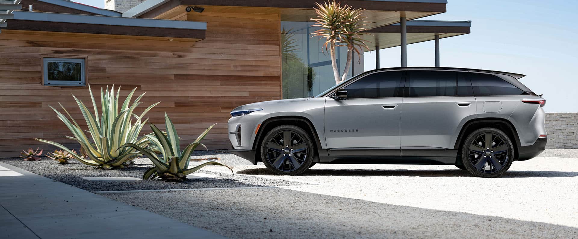 On the left, an angled passenger-side profile of a black 2024 Jeep Wagoneer S Obsidian with the background blurred. In the middle, an angled passenger-side profile of a silver 2024 Jeep Wrangler Rubicon 4xe with a star-filled background. On the right, an angled driver-side profile of a white 2024 Jeep Grand Cherokee Summit Reserve 4xe parked on a clearing off-road at night, with the northern lights in the background.